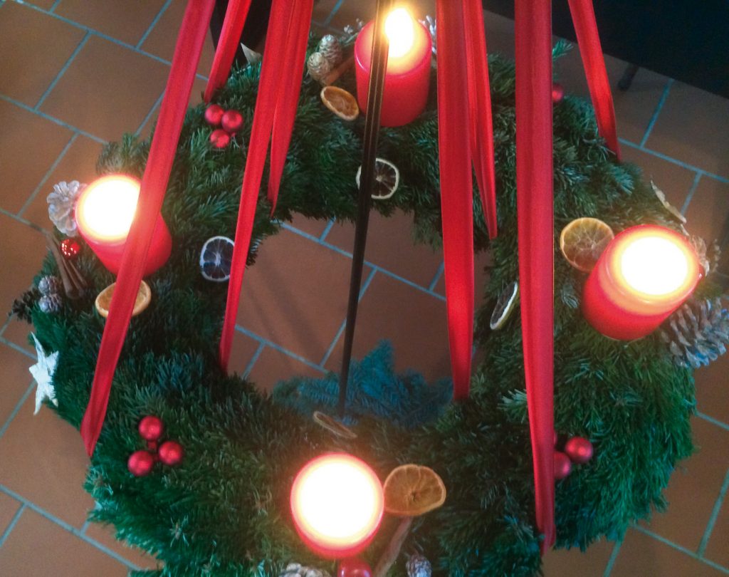 Adventskranz mit vier großen roten Kerzen