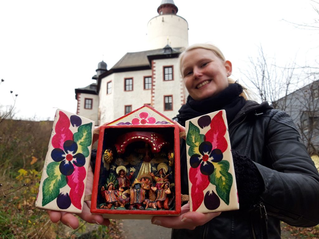 Junge Frau mit Weihnachtskrippe aus Peru